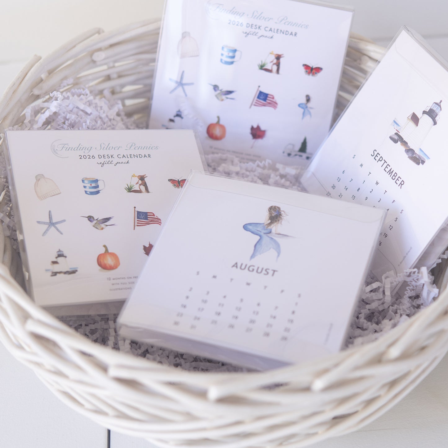 Small desk calendars refill packs with illustrations in a woven basket