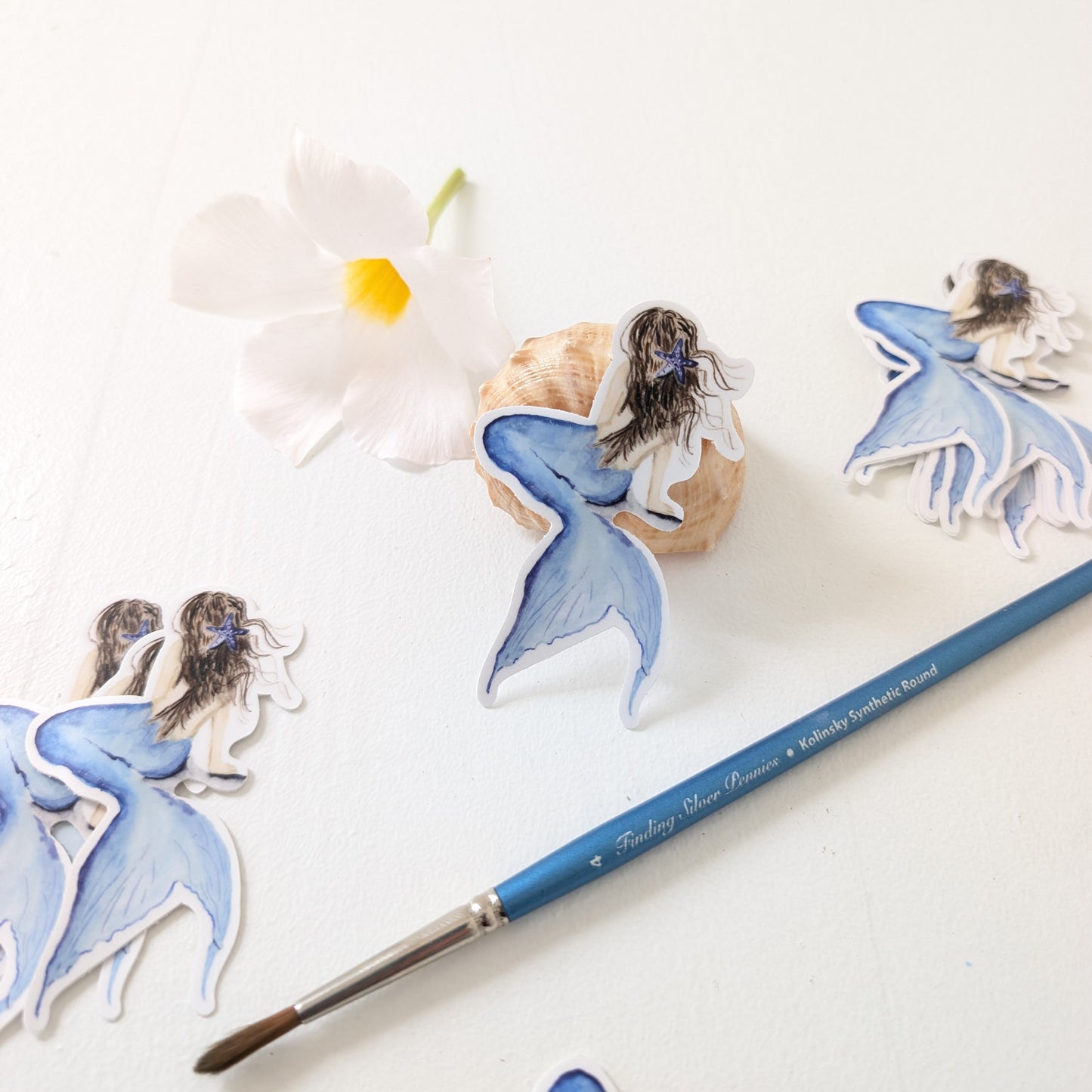 Mermaid stickers and a paintbrush on a white background