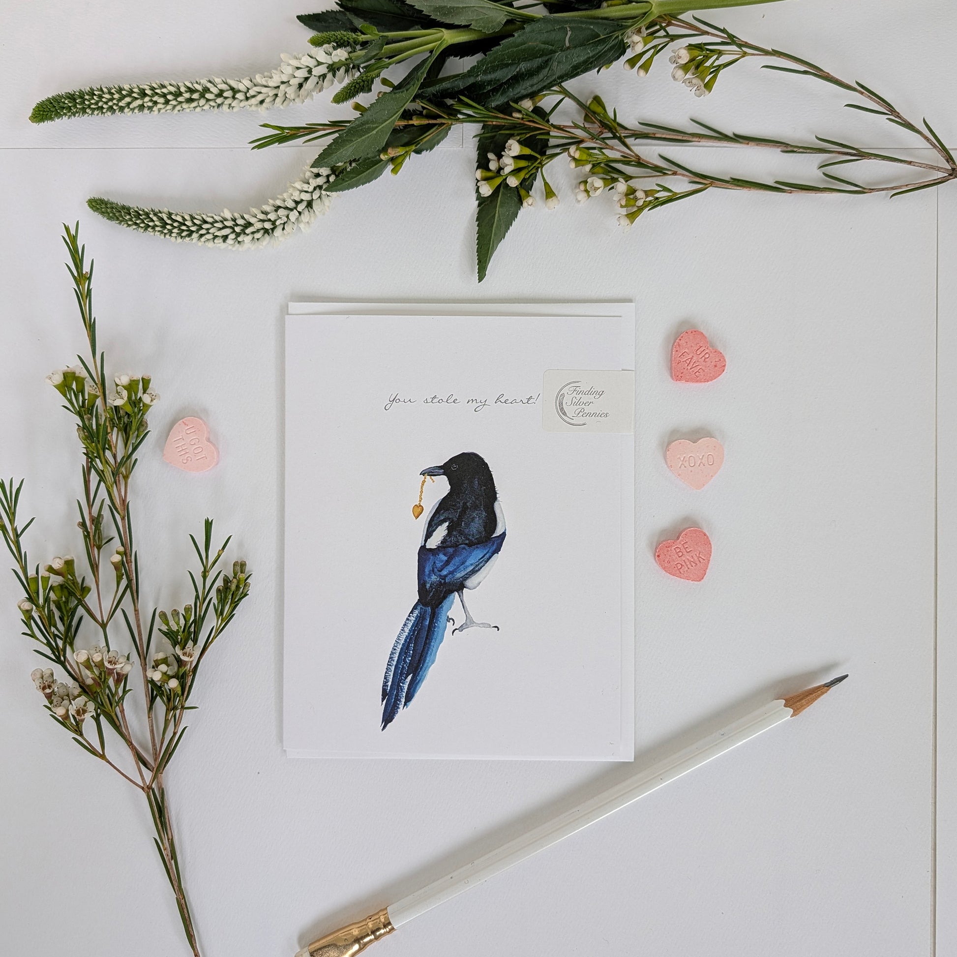 Card with a bird illustration surrounded by flowers and hearts on a white background