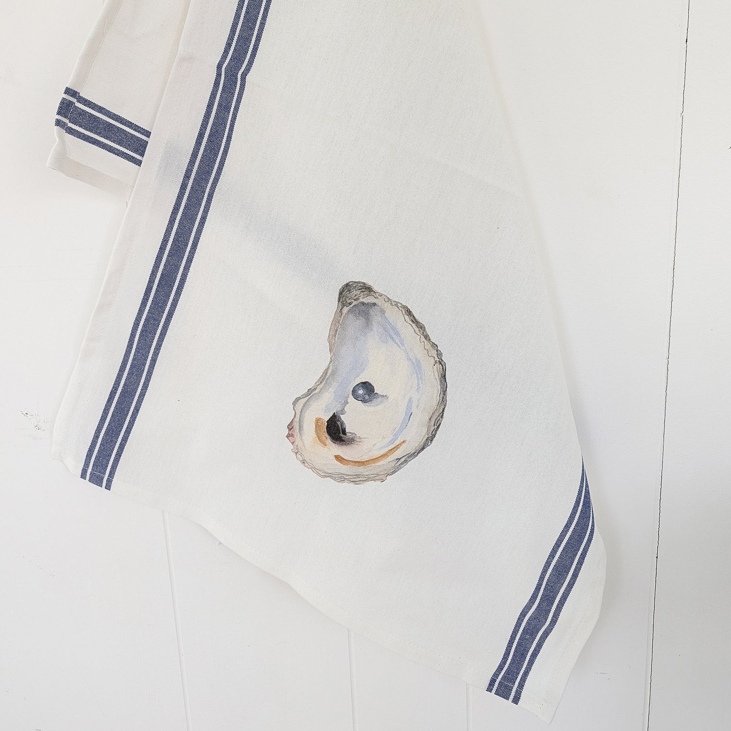 Oyster shell on a white cloth with blue stripes