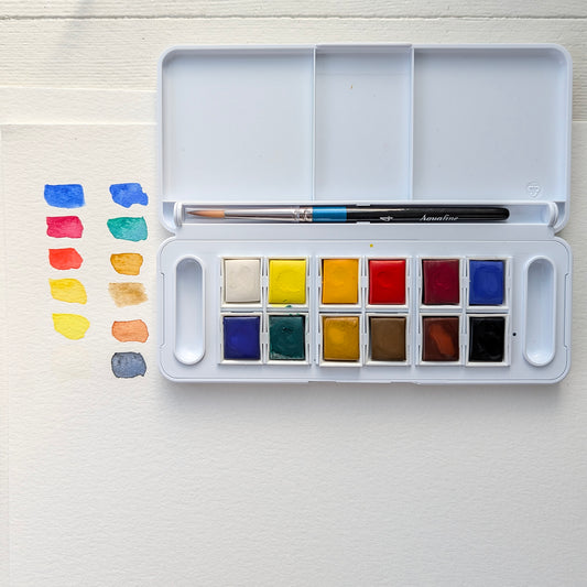 Watercolor paint set with colors swatched on a white surface