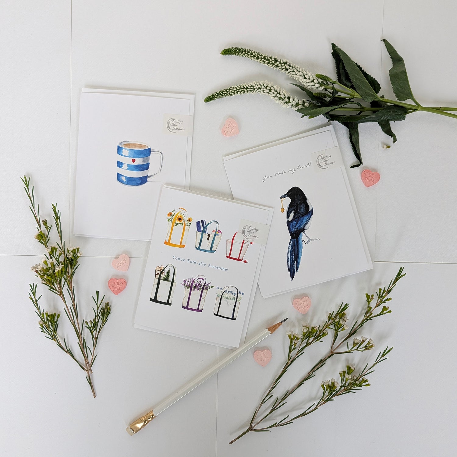 Set of Valentines greeting cards with illustrations on a white surface with green branches and pink hearts.