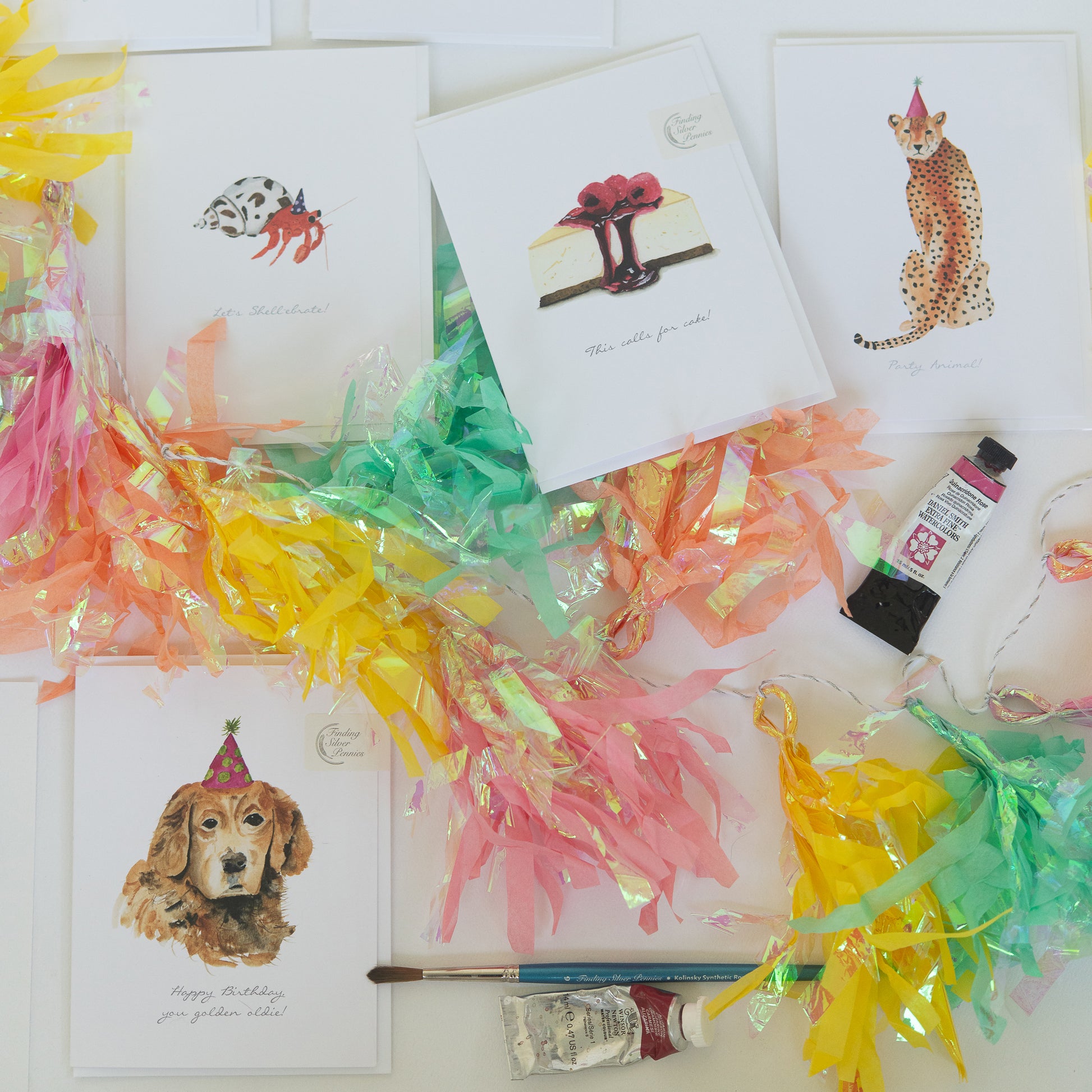 Colorful party streamers with cards featuring animals and a dog wearing a party hat on a white background.