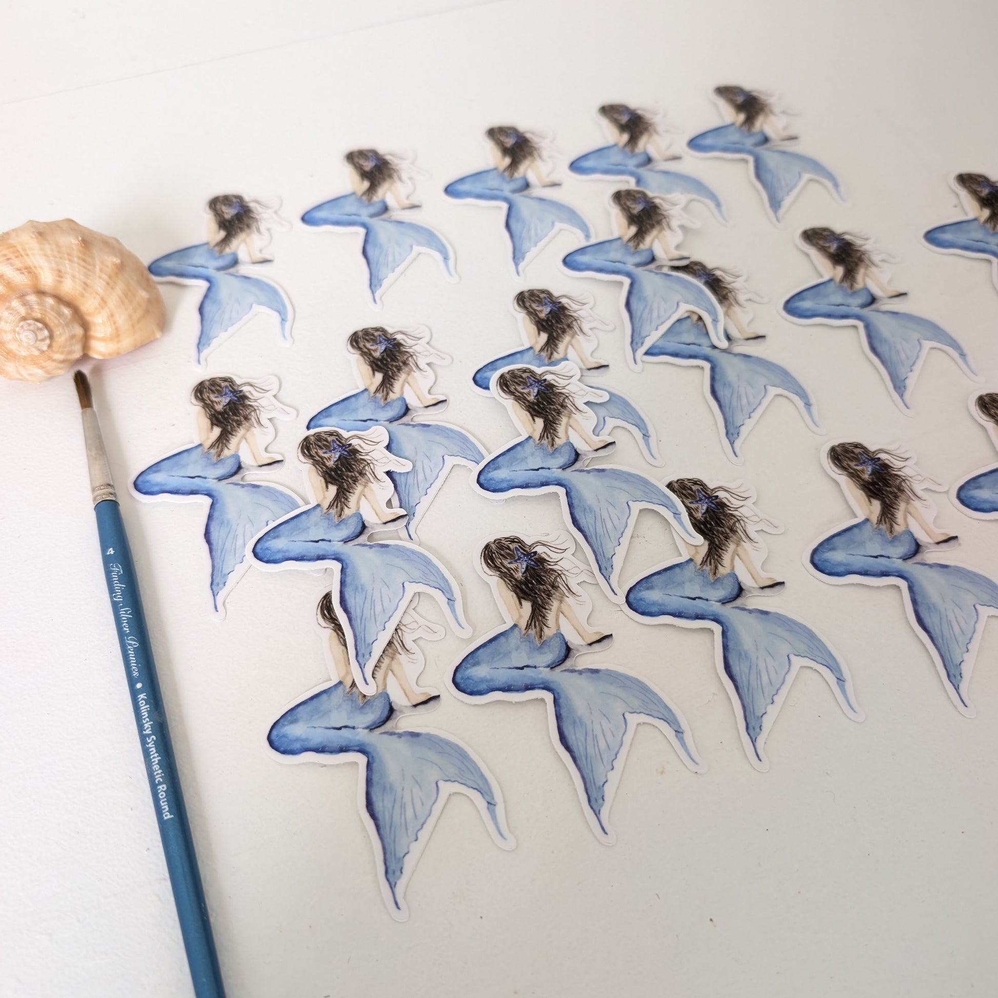 Mermaid stickers on a white background with a paintbrush and shell.