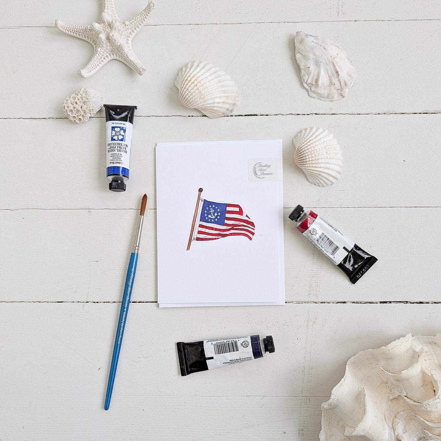 Yacht Ensign Note Card with paint tubes, brush, and shells on white wood background