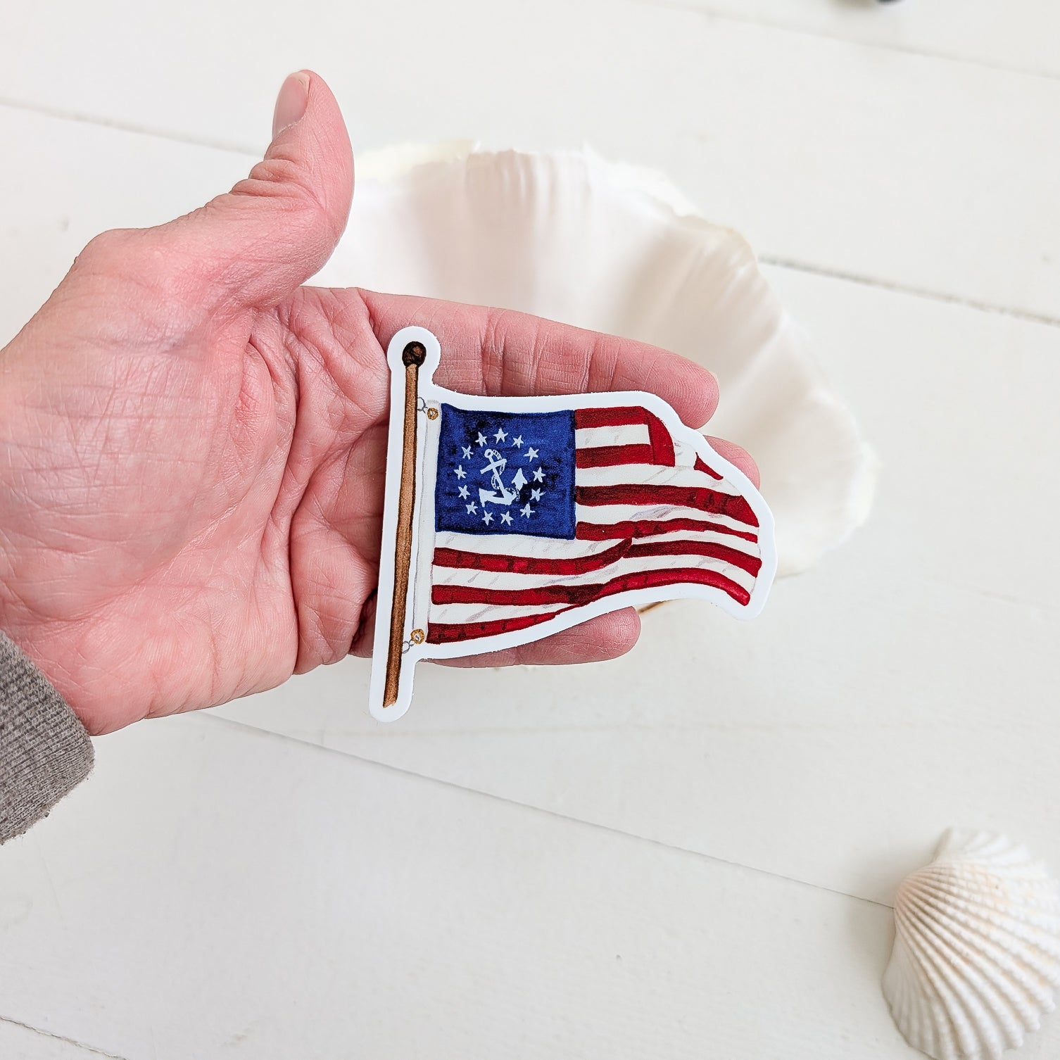 Hand Holding a Yacht Ensign Sticker