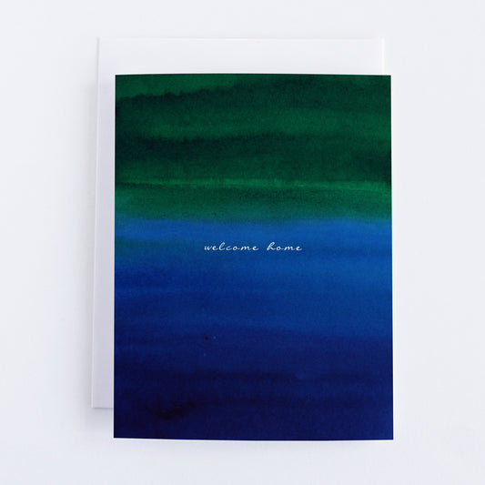 Greeting card with green to blue gradient and 'welcome home' text
